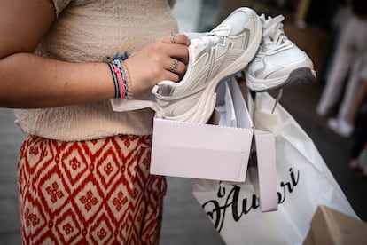 A girl shows the shoes that have been bought.