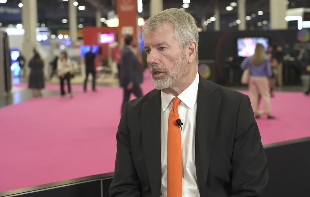 Michael Saylor in an interview, wearing a dark suit and orange tie, at the Money 20/20 event in Las Vegas.